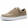 Pair of brown sneakers with white soles on a cardboard box.