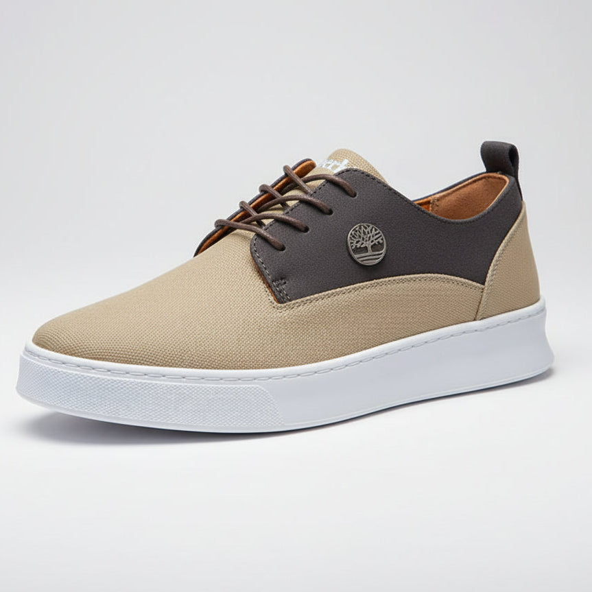 Beige and brown shoe with a visible brand logo held by a person.