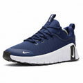 Blue Nike sneakers with white soles on a beige surface, with a Nike box in the background.
