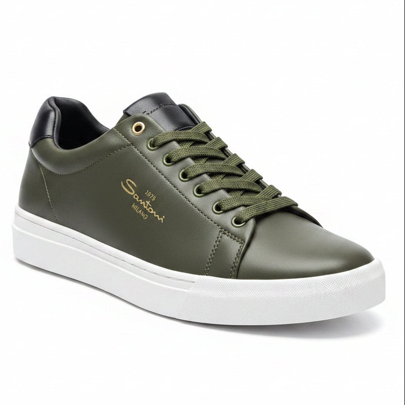 Green sneaker with white sole held by a hand on a blurred background